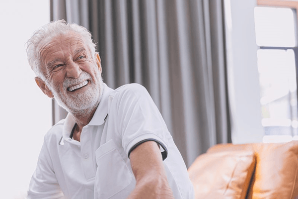 a mature man smiling after receiving his dental implants