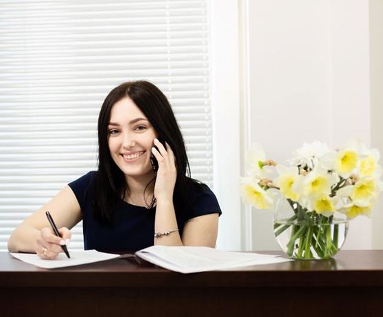 Smiling woman behind dental office front desk