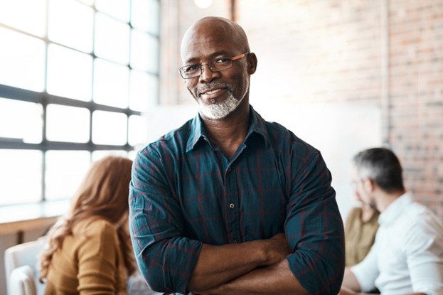 Smiling man standing with his arms crossed