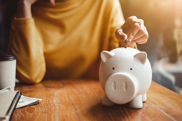 Person putting money in a piggy bank