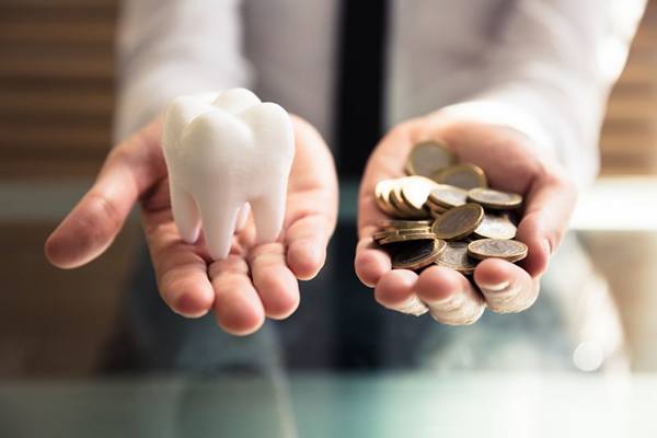 Tooth balanced with a pile of coins