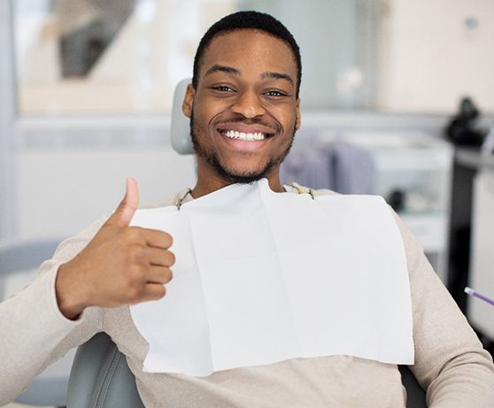 Man at oral surgeon’s office giving a thumbs up