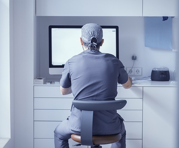 Oral surgeon sitting at computer