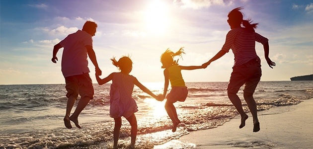 Family of four on the beach at sunset