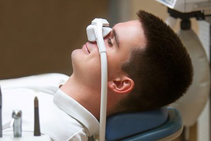 Male dental patient wearing nitrous oxide mask