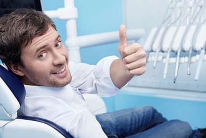 Happy dental patient making thumbs up gesture