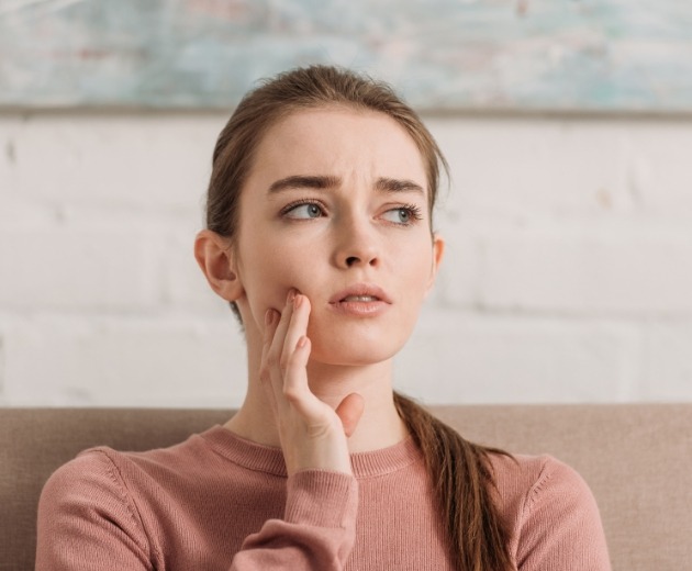 Young woman holding her jaw in pain