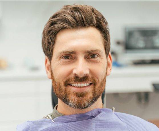 Close-up of smiling man in dental treatment chair