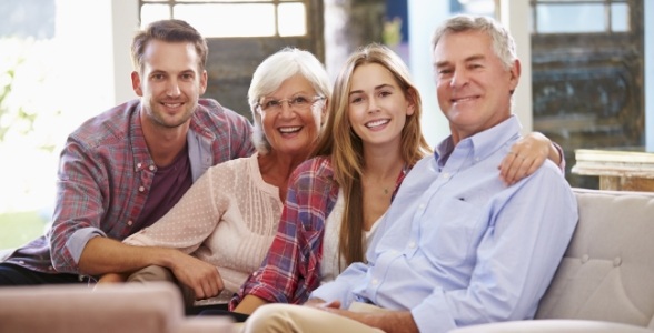 Smiling family of four sitting on couch