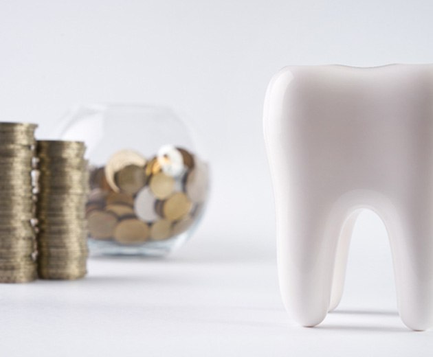 Tooth next to a jar of coins