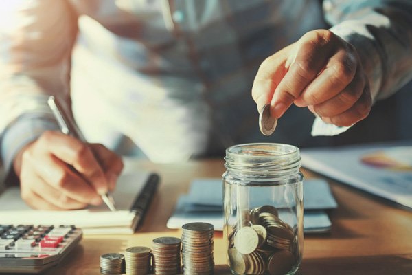 Someone putting coins into a jar