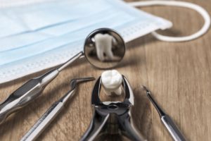 Extracted tooth and dental instruments on desk