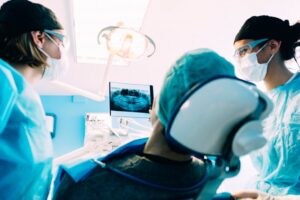 oral surgeons showing a patient their X-ray 