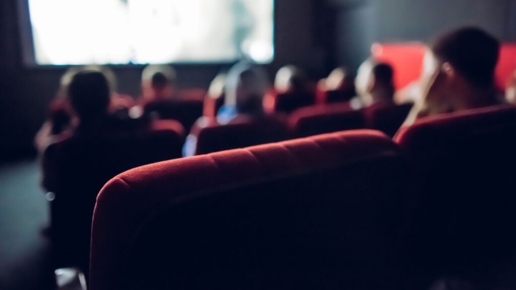 Blurry view of group of people watching movie in small theater